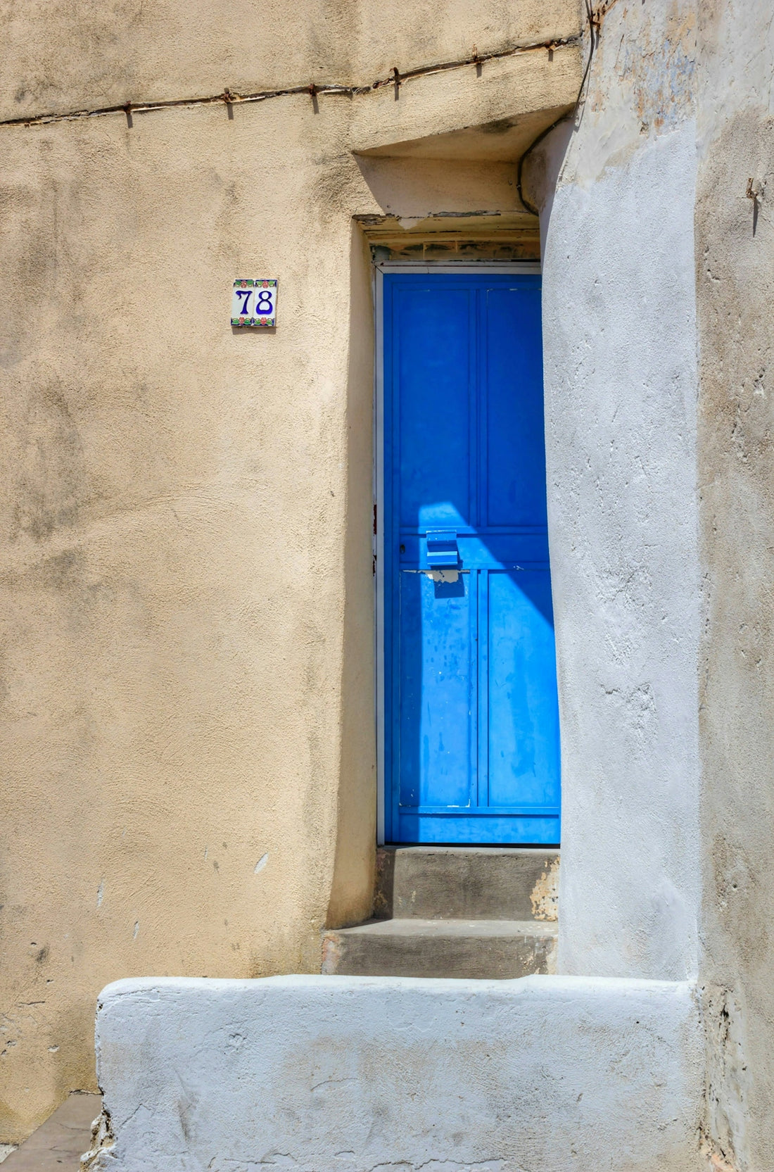 a blue door and steps in front of a building