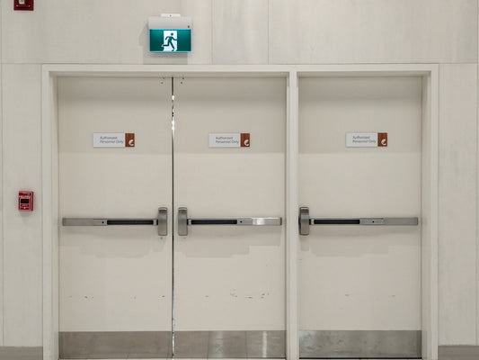 a white room with two doors and some signs on the doors