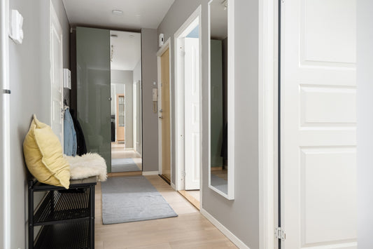 A hallway with a bench and a mirror