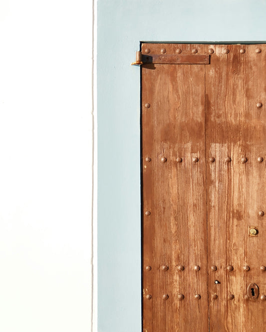 A wooden door with rivets on the side of it