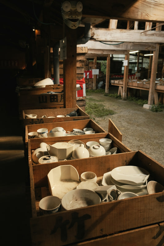 A row of wooden boxes filled with white dishes